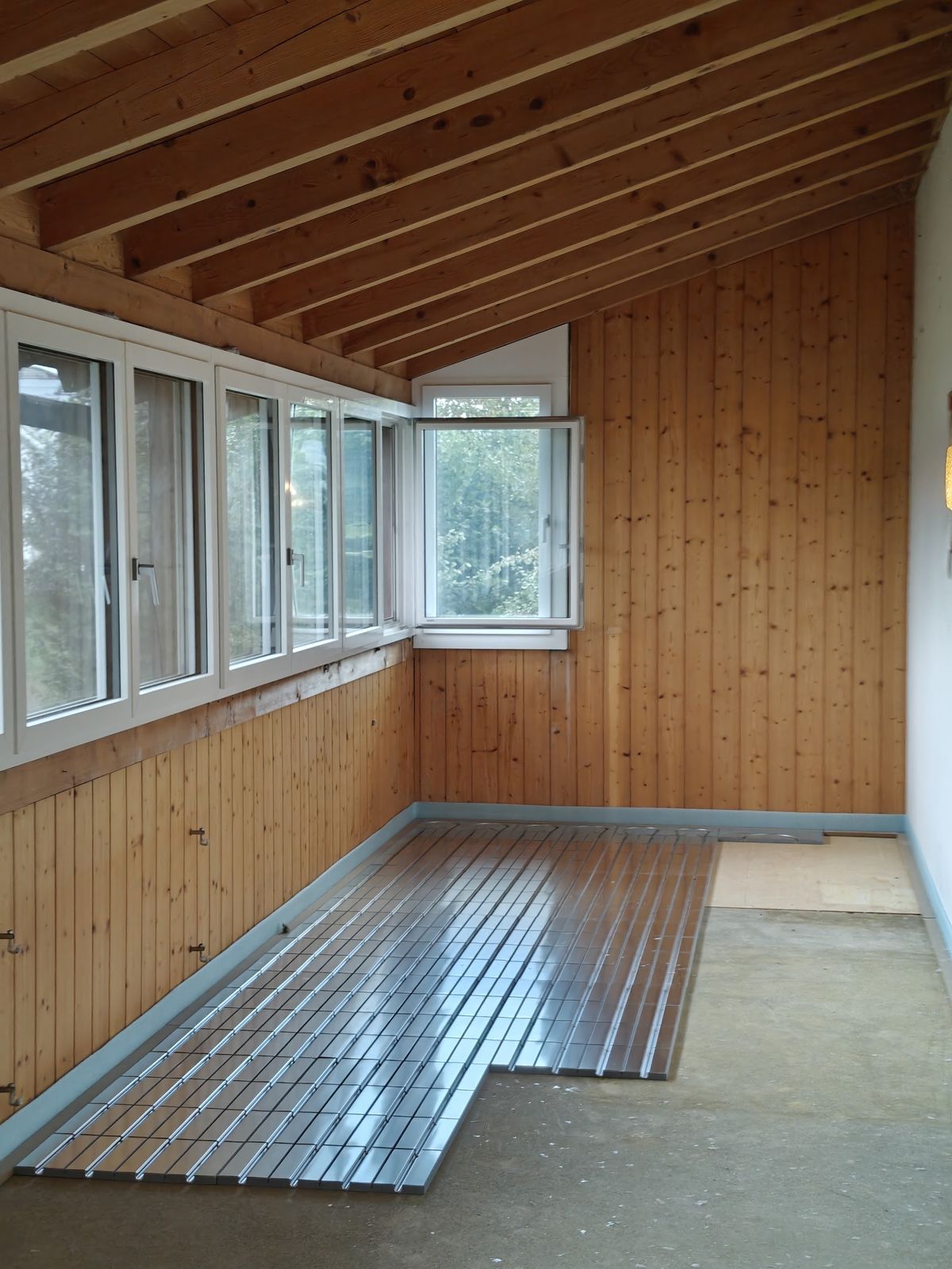 Dachausbau mit Holzverkleidung und verlegten Systemplatten im Boden